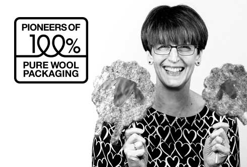 Founder of Woolcool, Angela, holding two wool sheep with the icon pioneers of 100% pure wool packaging